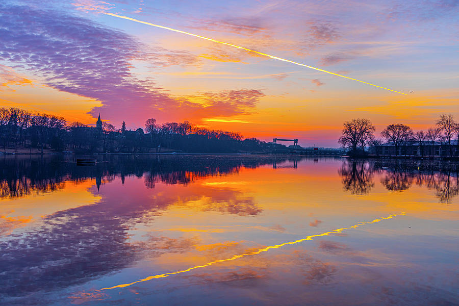 Scenic Photograph - Stunning dawn sky with jet streak, reflected in river by James Brey