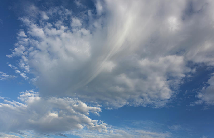 Stunning view of a vibrant sky with a mix of blue hues and billowing white clouds Photograph by Chris Anson