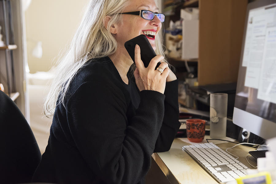 Stylish 50+ woman working from home. Photograph by Martinedoucet