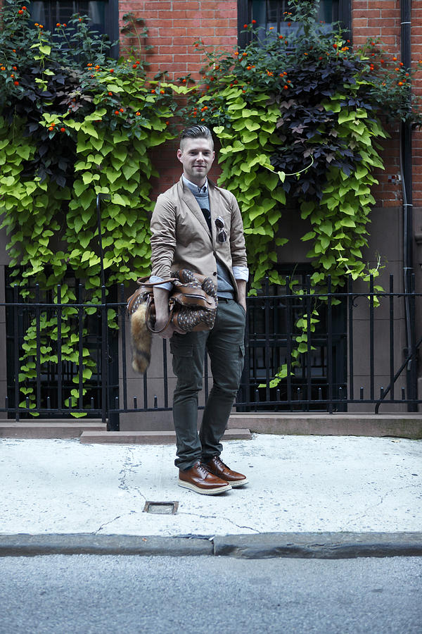 Stylish man with bag on city street, portrait Photograph by Tim Kitchen