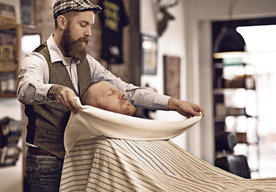 Stylish retro bearded barber with a bearded bald male client Photograph by Lorado