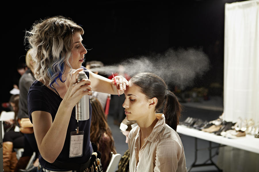 Stylist and model backstage at fashion show Photograph by Thomas Barwick