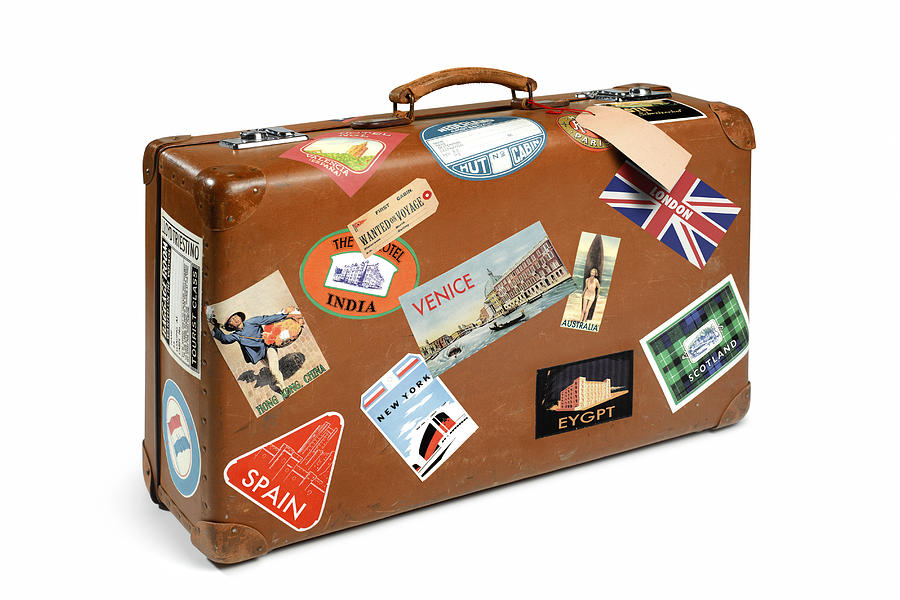 Suitcase with travel stickers Photograph by Peter Dazeley
