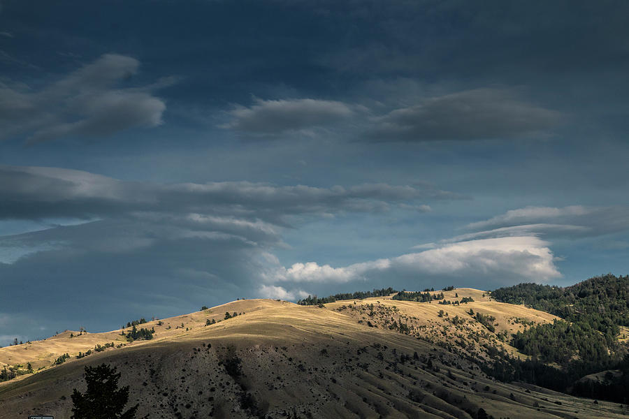 Sun light on a Ridge with Clouds in Yellowstone National Park Photograph by Randall Nyhof