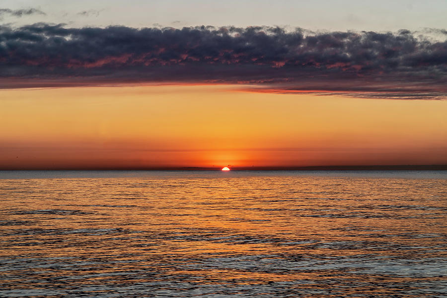 Sun peaks over watery horizon  Photograph by Sven Brogren