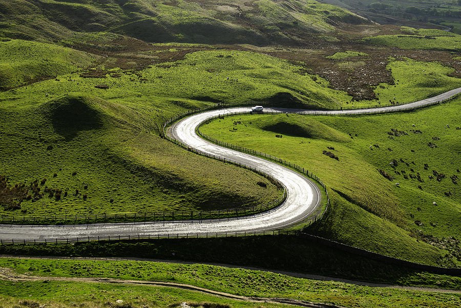 Sun reflecting on sinuous curving road in the English Peak District Photograph by John Lamb
