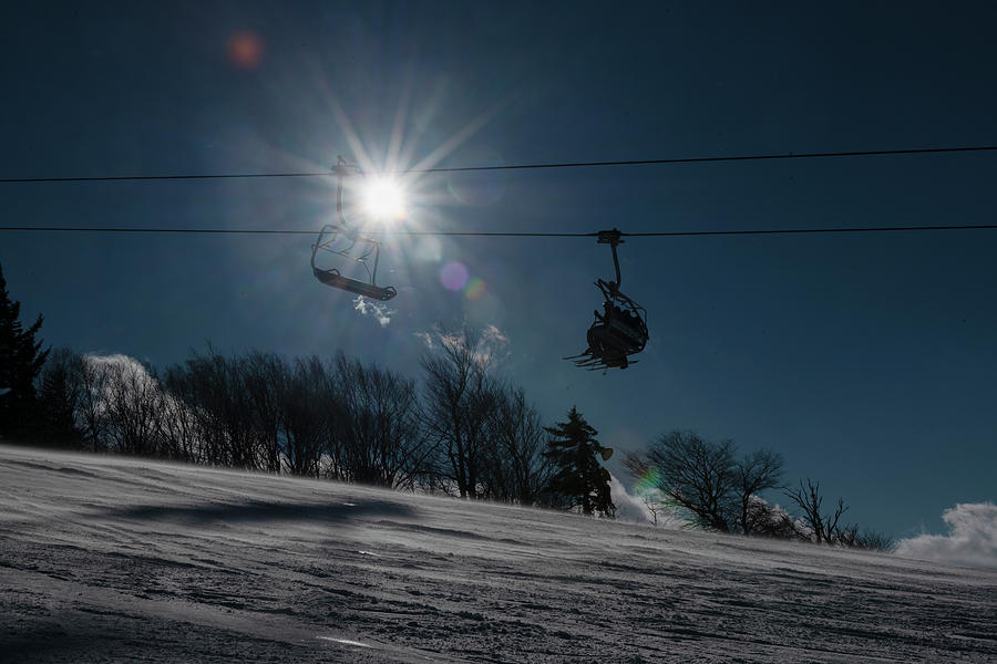 Sunburst behind ski lift with blue sky Photograph by Dan Friend