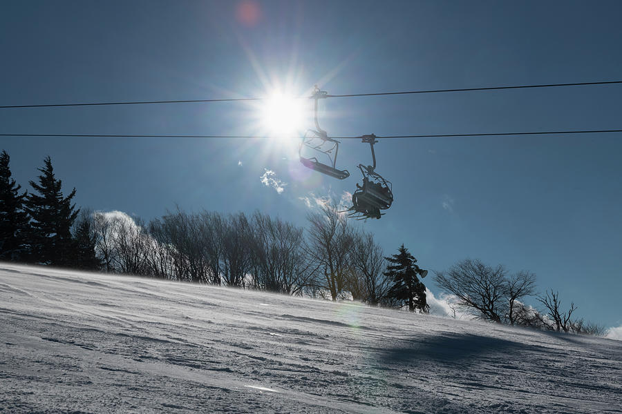 Sunburst behind ski lift with blue sky winter day Photograph by Dan Friend