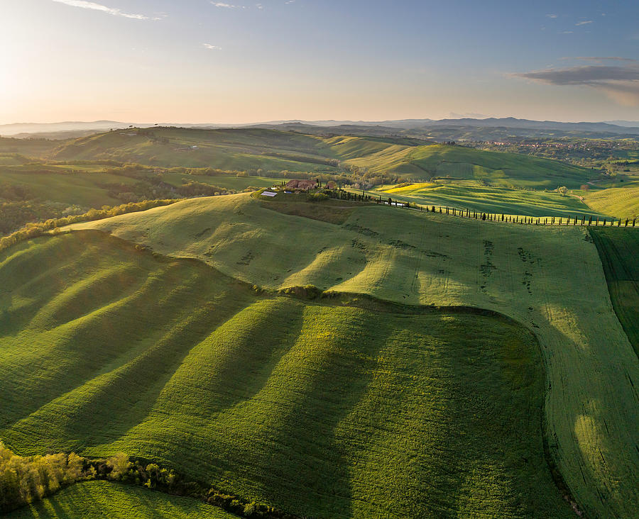 Sunlit rolling landscape in Tuscany bathing in late afternoon sunlight and seen from the air Photograph by Daniel Bosma