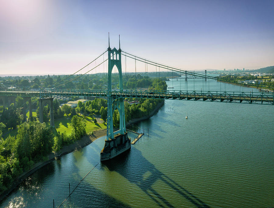 Sunrise aerial of St. Johns Bridges gothic towers, long shadows, and vivid blue sky in Portland. Photograph by Chris Anson
