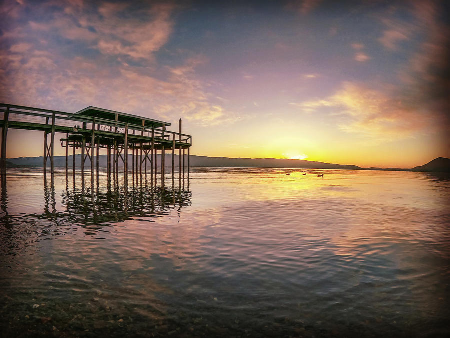 Sunrise shining down on a dock over Clearlake in California  Photograph by Devin Wilson