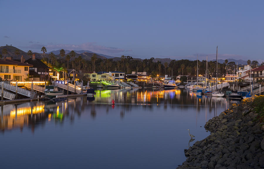 Sunset and dusk at residential development of modern homes and boats by water with Christmas lights in Ventura, California, USA Photograph by Steve Heap