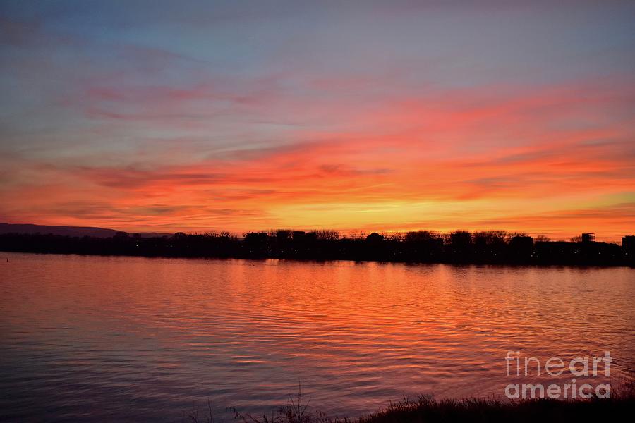 Sunset draped in vermilion over the river  Photograph by Leonida Arte