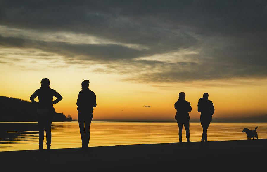 Sunset in Koper, Slovenia with people watching over the horizon ...