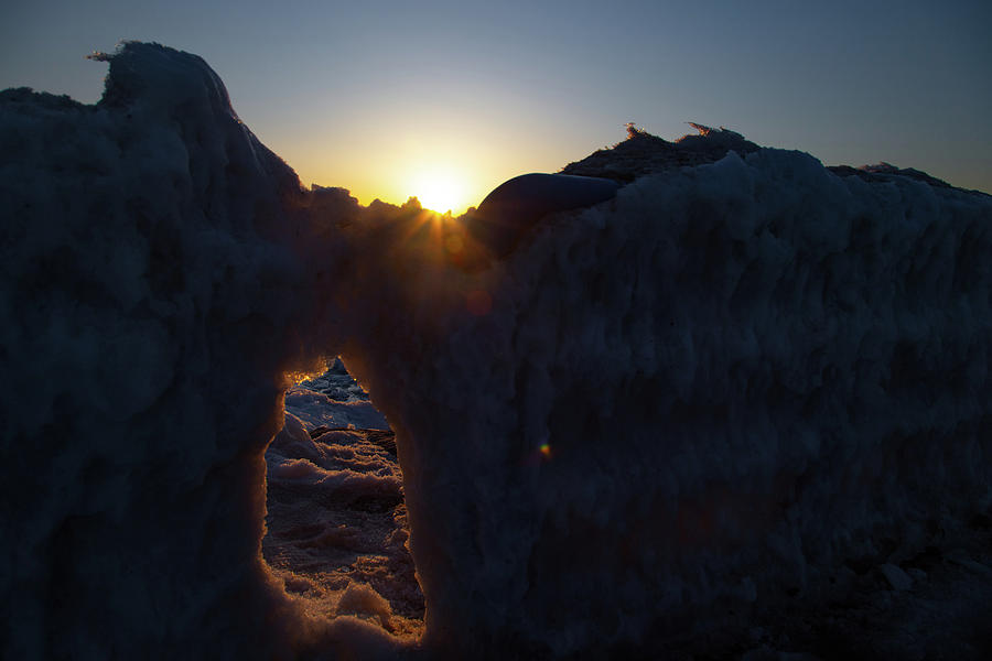 Sunset peaking over ice in Holland Michigan Photograph by Eldon McGraw