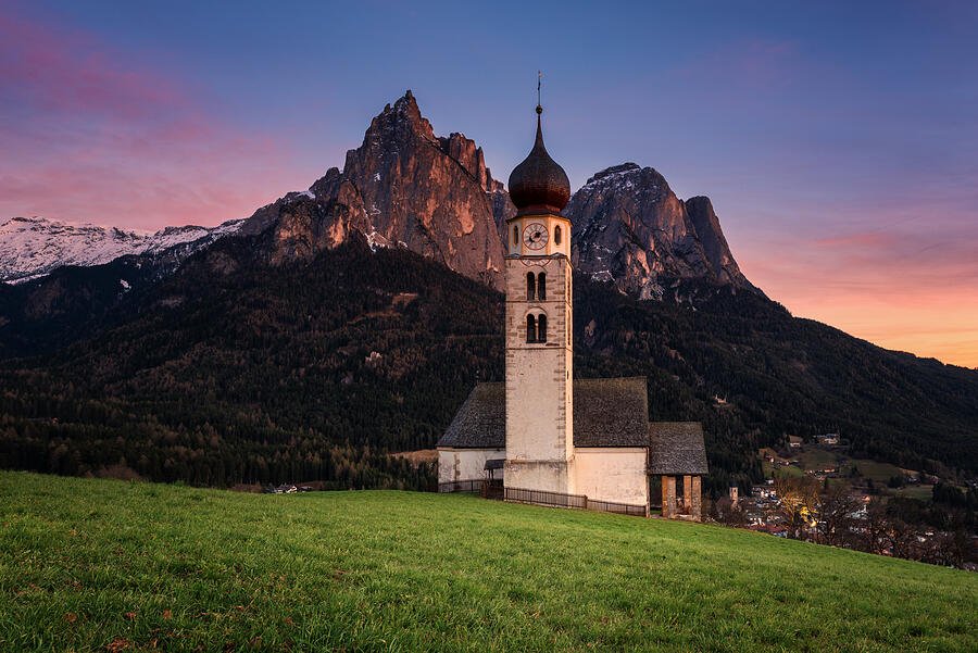 Sunset scenery of Church St.Valentin at Kastelruthand jagged rocks of Schlern background. Photograph by Aumphotography