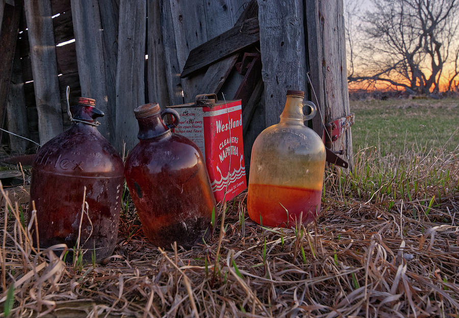 Sunset Still Life  - jugs and a red can at an abandoned farm shed Photograph by Peter Herman