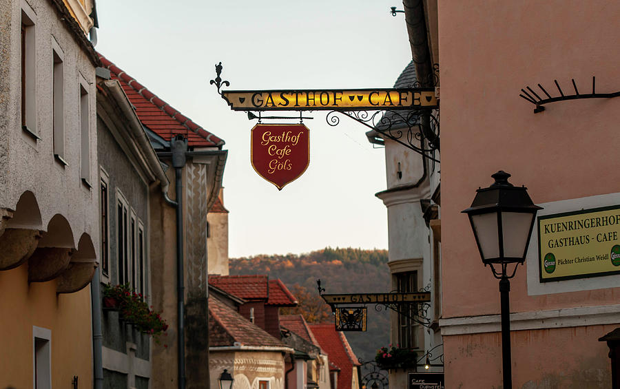 Sunset Walks In Durnstein. Main Street and Forged Signs Photograph by Jenny Rainbow