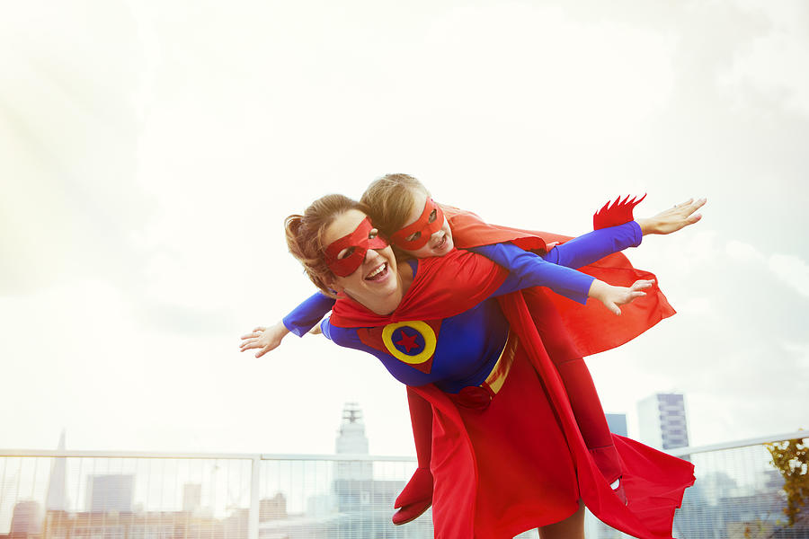 Superhero mother and daughter playing on city rooftop Photograph by Robert Daly