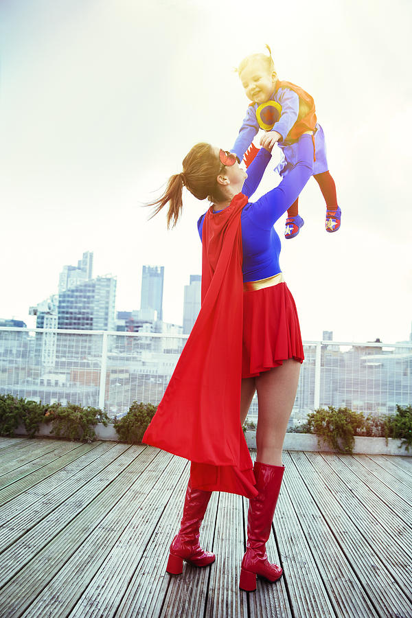 Superhero mother playing with daughter on city rooftop Photograph by Robert Daly