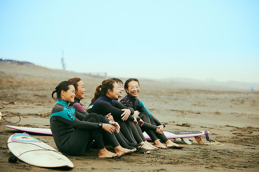Surfer women are talking on beach in the rain Photograph by Yoshiyoshi Hirokawa