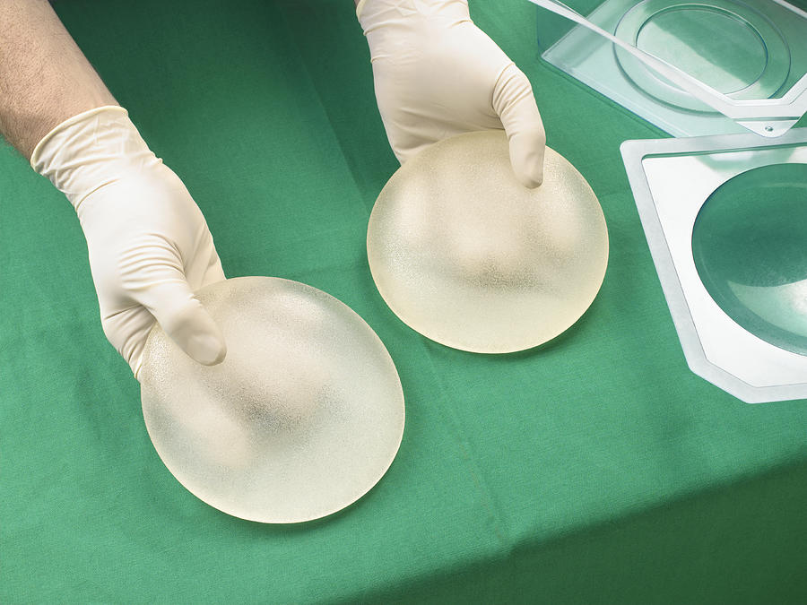 Surgeon holding silicone breast implants, close-up, elevated view Photograph by Peter Dazeley