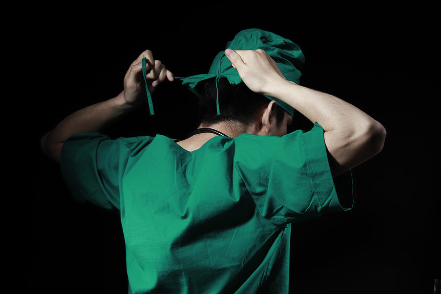 Surgeon tying surgical cap Photograph by Runstudio