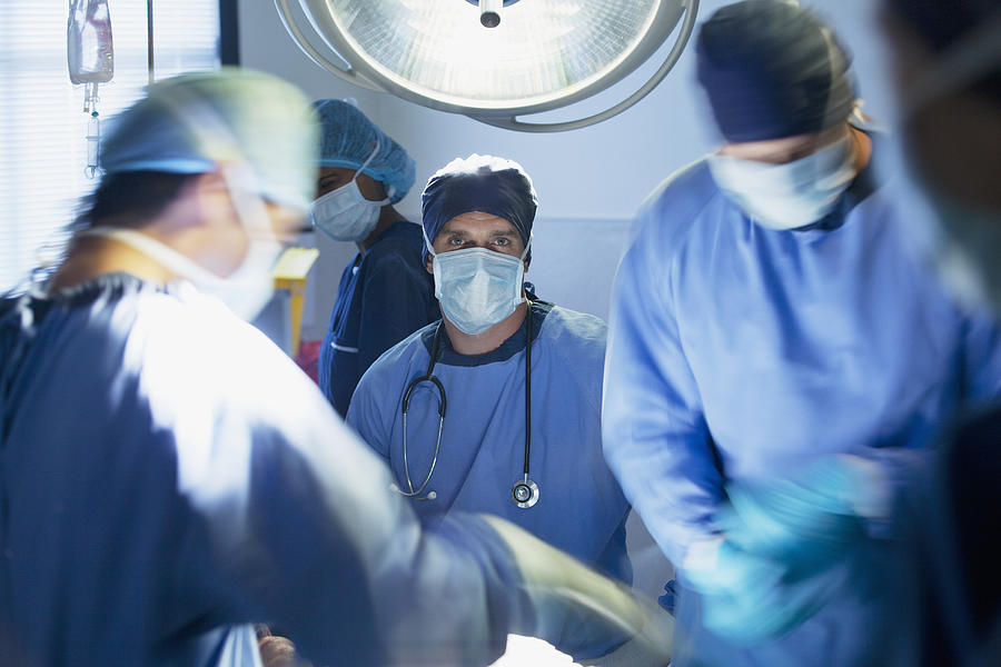 Surgeons in operating room Photograph by Sam Edwards