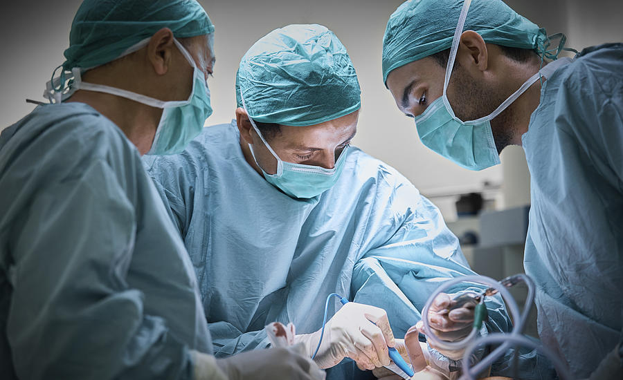 Surgeons operating patient for breast implant Photograph by Morsa Images
