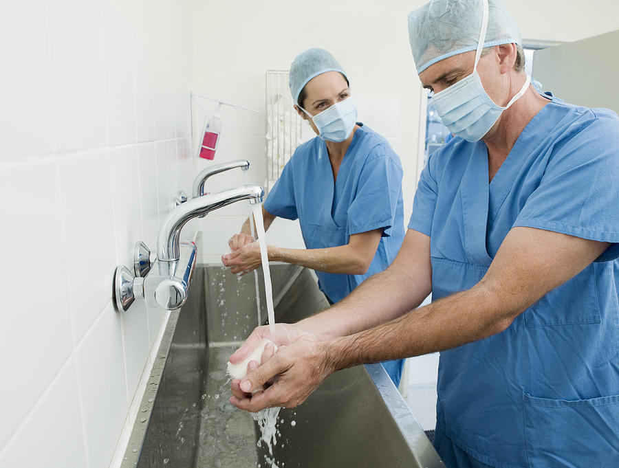 Surgeons washing hands before operation Photograph by Chris Ryan