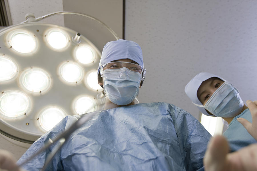 Surgeons working in operating room, low angle view Photograph by Michael H