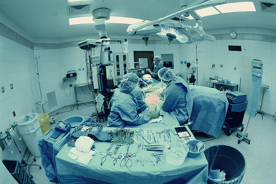 Surgical team in operating room Photograph by Robert Llewellyn