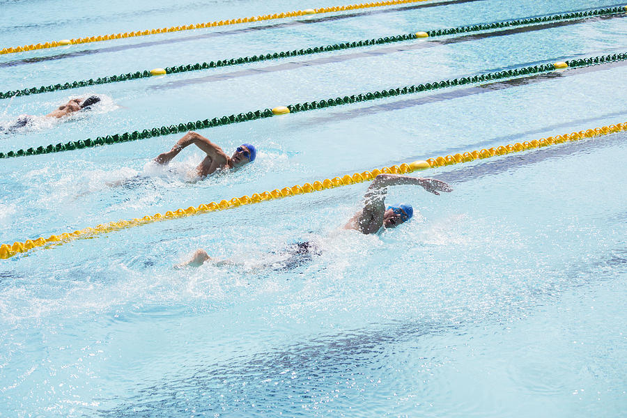 Swimmers racing in pool Photograph by Caia Image
