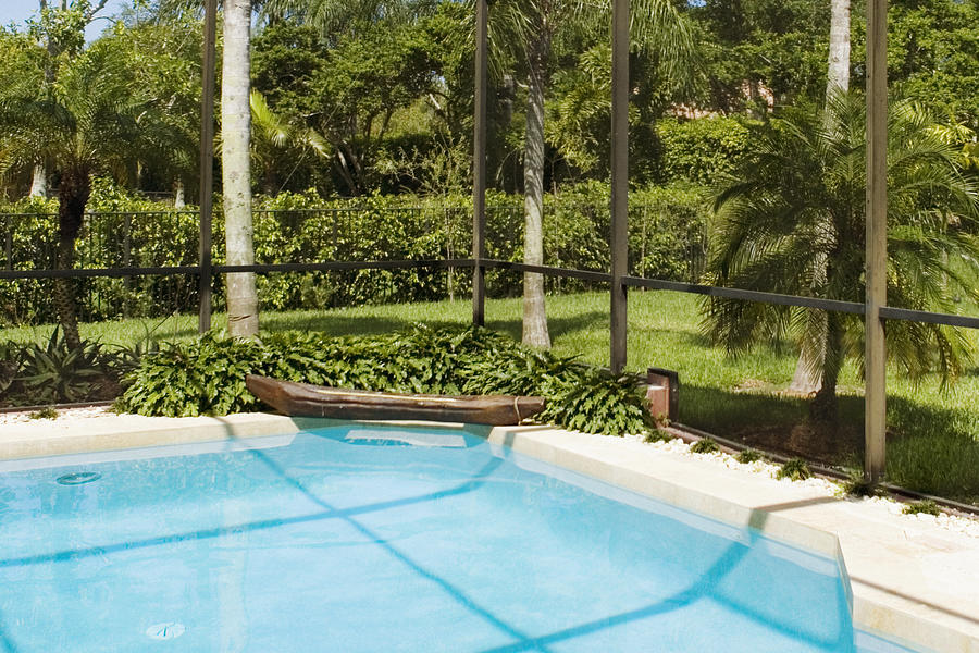 Swimming pool in a garden Photograph by Glowimages