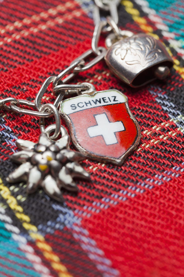 Switzerland, Swiss flag on charm bracelet with cow bell and edelweiss Photograph by Westend61