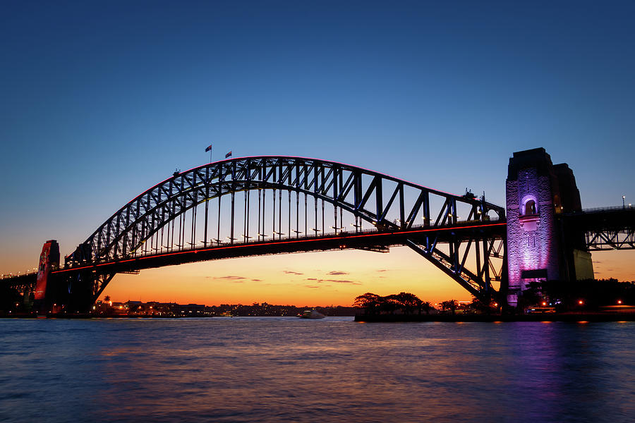 Sydney Harbour Bridge illuminated at sunset Photograph by Rick Deacon