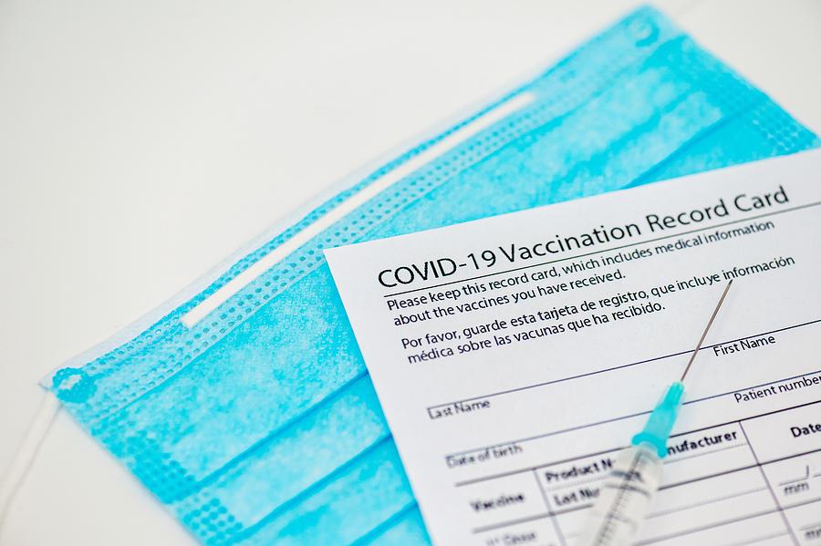 Syringe and vaccination record card Photograph by Stefan Cristian Cioata