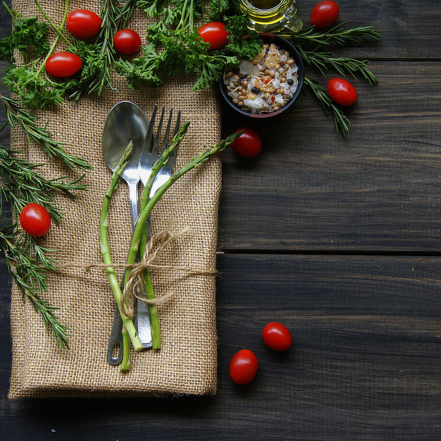 Table with cutlery, herbs, tomatoes and spices Photograph by Wild_Drago