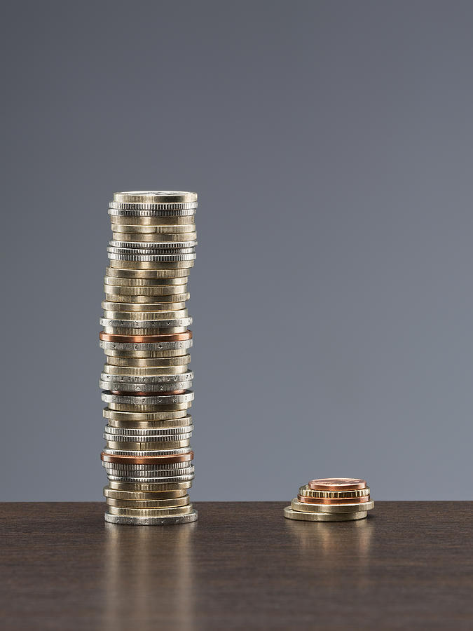 Tall stack of coins next to short stack of coins Photograph by Andy Roberts