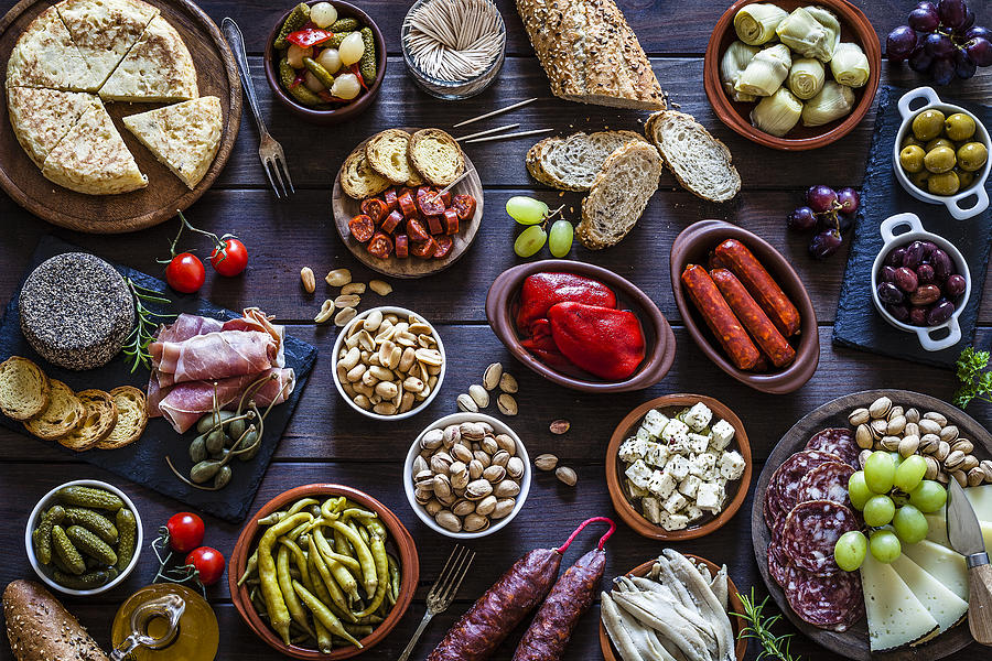 Tapas on rustic wooden table shot from above Photograph by Fcafotodigital