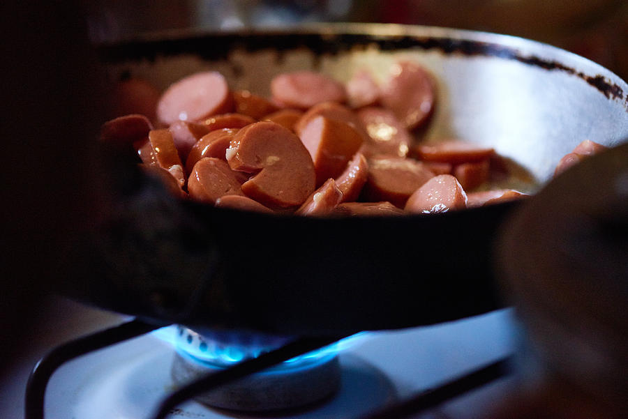 Tasty cut sausage in frying pan Photograph by CliqueImages