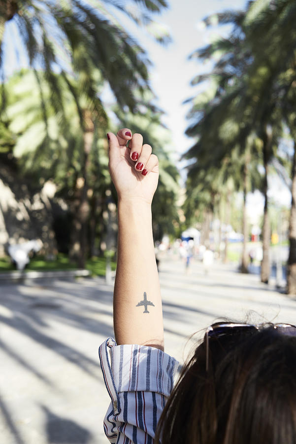 Tattoo of an airplane on forearm of young woman Photograph by Westend61
