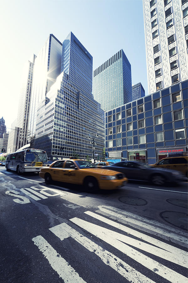 Taxi At Manhattan Morning Street Traffic With Skyscrapers In Sun Photograph by Sebastian-julian