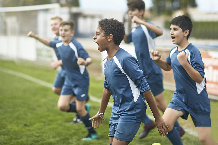 Team of Confident Young Male Footballers Running Onto Field Photograph by Xavierarnau