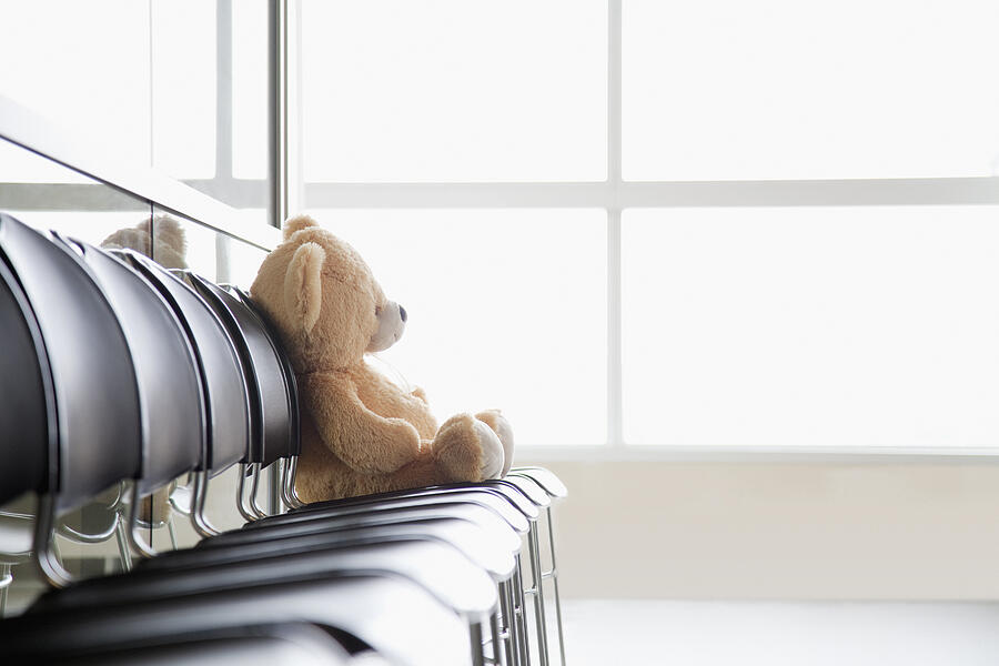 Teddy bear sitting on chair on hospital corridor Photograph by Drew Myers/Corbis/VCG