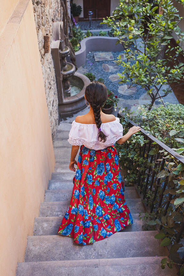 Teen girl in traditional dress decending staircase Photograph by Tony Anderson