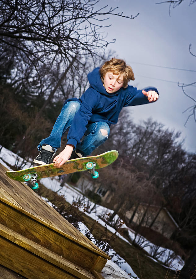 Teen jumping his skateboard off deck Photograph by Randy Riksen Photography