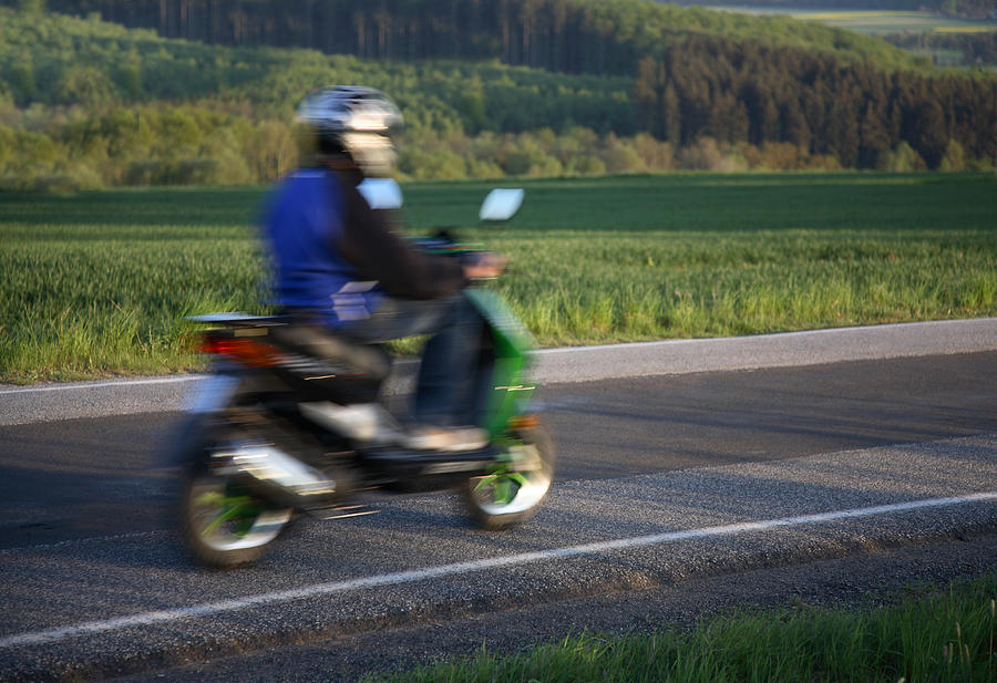 Teen riding home on his moped, motion blur Photograph by Bim