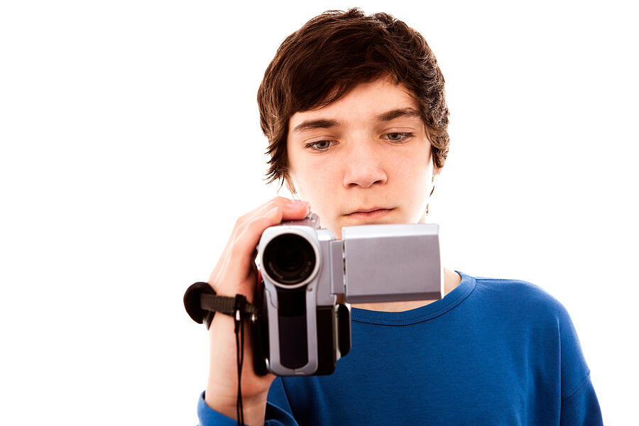 Teenage Boy Holding Video Camera, Close Up Studio Portrait Photograph by Maodesign