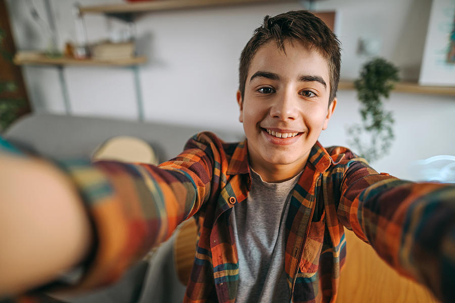 Teenage boy making selfie at home Photograph by Mixetto
